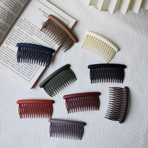 Close-up of 8-color matte hair side combs set on fabric for hairstyling fix