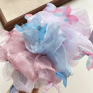 Détail de chouchous en organza avec papillons roses, bleus et blancs ornés de strass