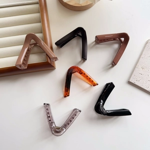 Top view of large triangular shark hair clips in various matte and glossy colors