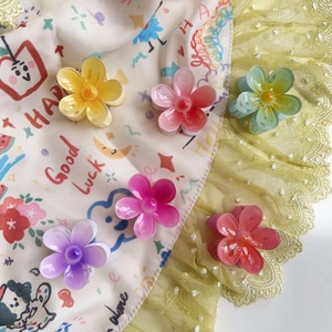 Close-up of six colorful flower hair claws in resin with central pearl accents