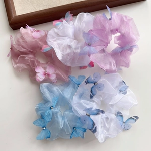 Détail de chouchous en organza avec papillons 3D et centres en strass brillants