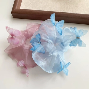 Détail de chouchous en organza papillon 3D avec strass en rose et bleu