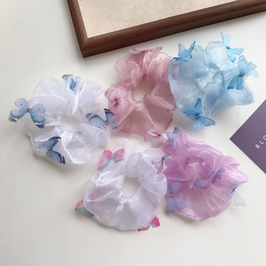 Détail de chouchous en organza avec papillons 3D aux tons pastels doux