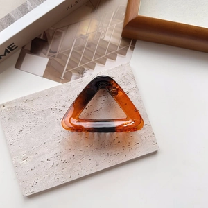 Close-up of amber tortoise shell triangular hair claw clip on stone display board