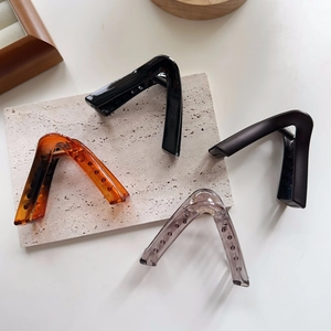 Set of four large V-shaped shark hair claws in glossy black, matte, and amber tones