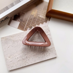 Macro view of coffee brown triangular hair claw clip on stone base with magazine