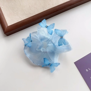Détail du chouchou en organza bleu clair avec papillons en mesh 3D et petits strass