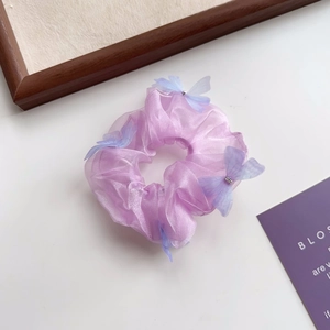 Détail d'un chouchou en organza violet clair avec papillons translucides et cristaux