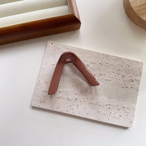 Macro view of triangular hair claw clip in warm brown resin on marble stone display