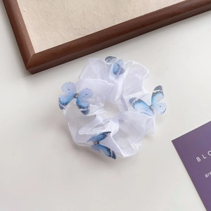 Détail de la texture du chouchou en organza blanc avec des papillons bleu dégradé