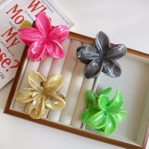 Dettagli di quattro fermagli per capelli a fiori colorati con trama in marmo su vassoio