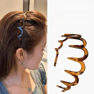 Detail showing wavy tortoiseshell headband with teeth for styling and hair volume
