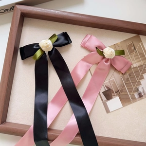 Elegant satin bow hair clips with rose decor in pink and black featuring long ribbons