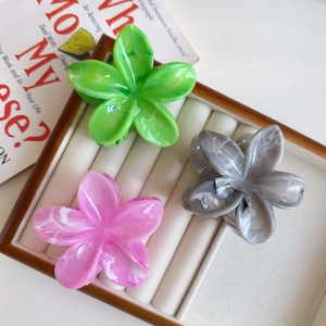 Tre fermagli per capelli a forma di fiore colorati in una scatola da esposizione in velluto