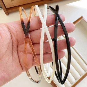 Detail view of non-slip teeth on minimalist cross hairbands in amber, white and black
