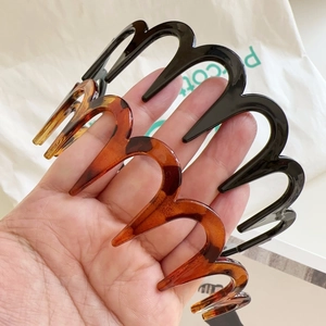 Detail view of wavy zig-zag headbands in tortoiseshell and glossy black resin