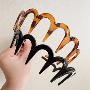Detail showing black and tortoiseshell wave hair hoops with teeth for a secure grip