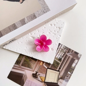 Detailed view of a rose pink flower hair claw clip on a stylish aesthetic background