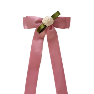 Pink satin bow hair clip with white fabric rose and long ribbons on white background
