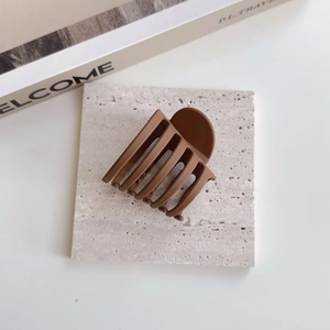 Détail de la grande pince à cheveux marron mat avec design à dents multiples