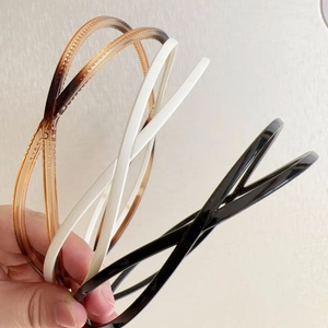 Close-up of three crisscross non-slip headbands in black, white and tortoiseshell patterns