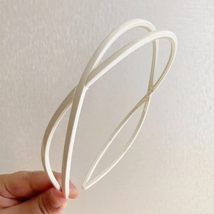 Close-up of a white double-layered crossover headband with non-slip interior teeth