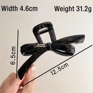 Elegant large black ribbon bow hair claw clip made of resin for stylish updos