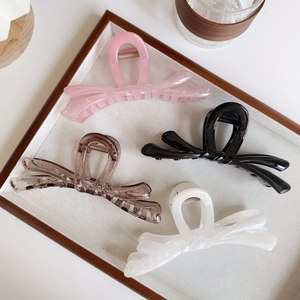 Lot de quatre pinces à cheveux en forme de nœud en rose, noir, marron et blanc perle