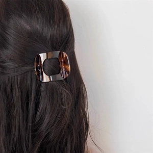 Detail view of large tortoiseshell hair claw clip used for elegant half-up hairstyle