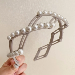 Détail du serre-tête pliable avec perles blanches et structure en losange gris ajustable