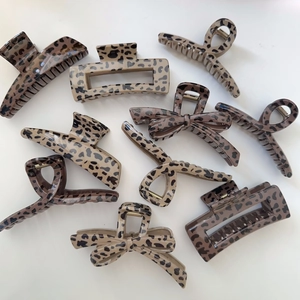 Flat lay of leopard print hair claws in various shapes including bows and crosses