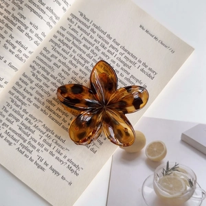 Primo piano di una grande pinza per capelli a fiore vintage in ambra e tartaruga francese