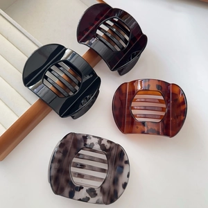 Detail view of large tortoise shell hair claws in four colors on a white background