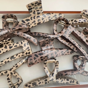 Selection of leopard print claw clips with bow and geometric designs on a jewelry tray