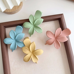 Détail de quatre pinces à cheveux à fleurs mates aux couleurs pastel Morandi