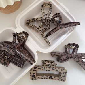 Detailed close-up of leopard print hair claws in various vintage bow and curved styles