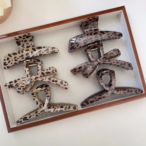 Detail view of leopard print hair claw clips in various shapes on a display tray