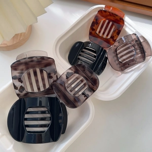 Five assorted retro tortoiseshell and marble square hair claws displayed on white paper
