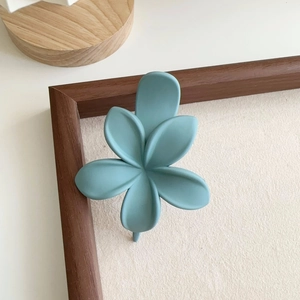 Vue détaillée d'une pince à cheveux en forme de fleur bleu mat de style Morandi