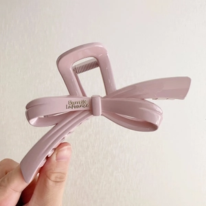 Detailed close-up of a pink resin bow claw clip with engraved Barrette LaFrance text