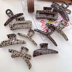 Detailed close-up of leopard print hair claws in various vintage bow and cross shapes
