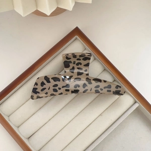 Detail of leopard print hair claw clip on velvet tray showing high-gloss resin finish