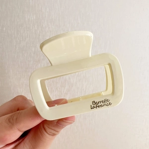 Détail d'une pince à cheveux carrée crème avec lettrage argenté Barrette La France