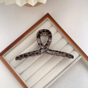 Close-up of leopard print hair claw clip showing glossy finish and metal spring mechanism