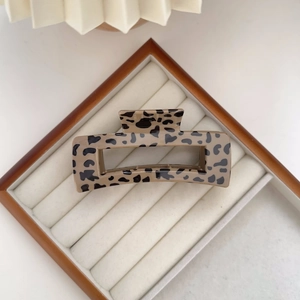Detailed top view of leopard print hair claw clip in a velvet jewelry display box