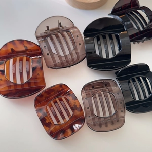 Detail view of large tortoiseshell hair claws with non-slip teeth in three colors