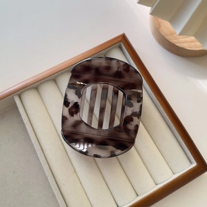 Detail view of the polished tortoiseshell pattern texture on a sturdy resin hair jaw clip