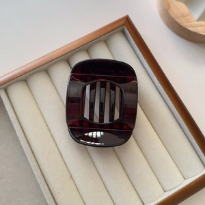 Detail view of large dark burgundy resin hair claw clip with square hollow design