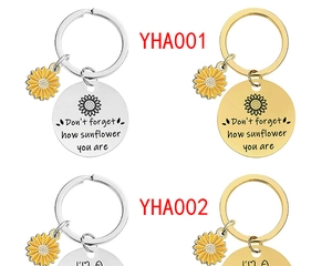 Detail view of engraved sunflower keychains in gold and silver finish with inspirational quotes