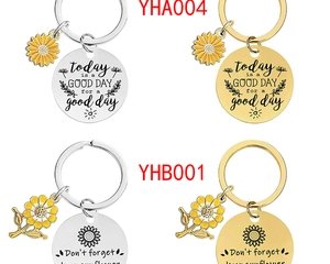Detailed macro of metal keychains featuring enamel sunflower charms and engraved quotes